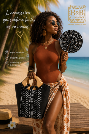 Femme portant un sac cabas en tissu wax africain avec éventail et pochette assortis, fabrication artisanale B&B Élégance, idéal pour un look chic et estival.